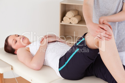Masseuse massing the knee of a cute woman