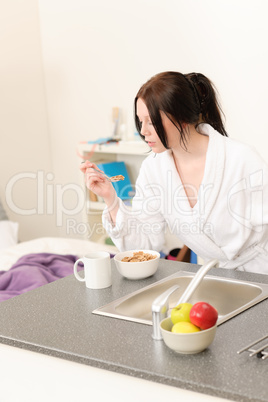 Young student girl eat cereal in kitchen