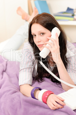 Young student girl speaking on phone lying