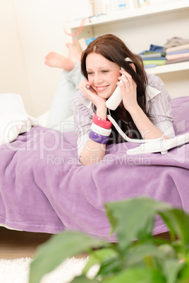 Happy student girl speaking on phone lying