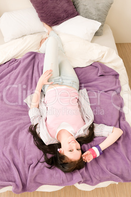 Young happy student relax lying on bed