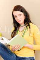 Young student girl reading book at home