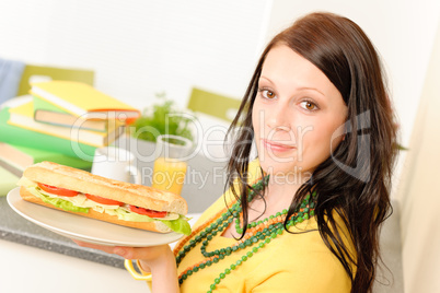 Young student girl eat sandwich in kitchen