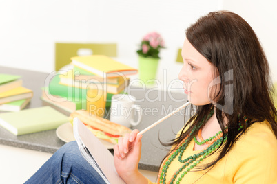 Young student girl thinking in kitchen