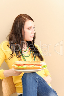 Young happy student girl eat fresh sandwich