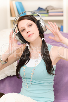 Young happy student with headphones listen music