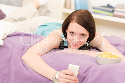 Young student girl on bed hold phone