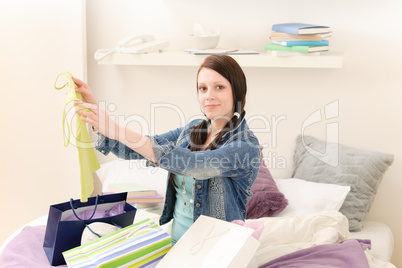 Young happy student girl unpack shopping bags