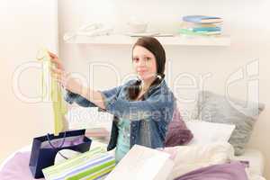 Young happy student girl unpack shopping bags