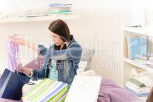 Young happy student girl unpack shopping bags