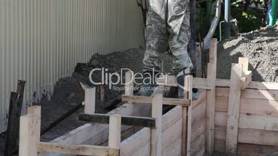 Worker pours the foundation of building