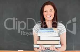 Smiling redhead bringing books