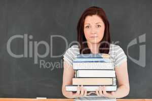 Cute young woman bringing heavy books