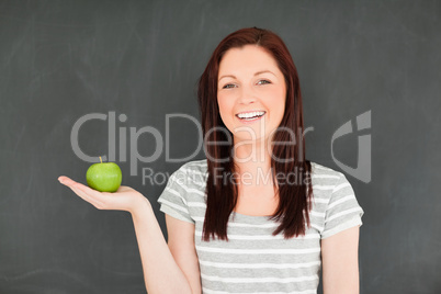 Young woman holding an apple on her palm