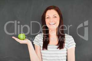 Young woman holding an apple on her palm