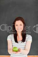 Portrait of a cute redhead against a blackboard