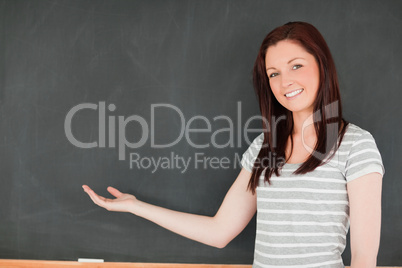 Smiling woman against blackboard with a copy space