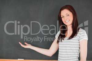 Smiling woman against blackboard with a copy space