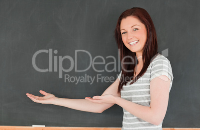 Red-haired woman against blackboard with a copy space