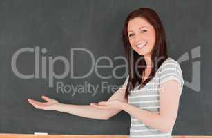 Red-haired woman against blackboard with a copy space