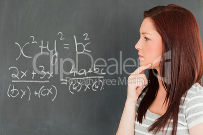 Pensive cute woman trying to solve an equation