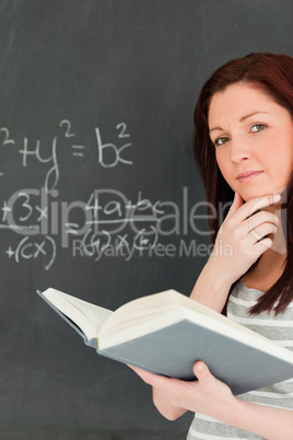 Portrait of a cute woman trying to solve an equation