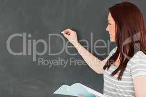 Focused beautilful woman writting on a blackboard