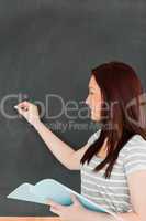 Focused young woman writting on a blackboard