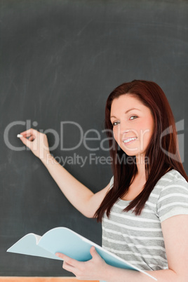 Portrait of a beautiful woman writting on a blackboard