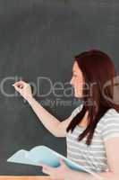 Portrait of a young woman writting on a blackboard