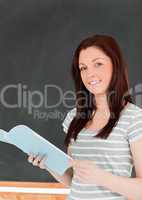 Portrait of a beautiful woman standing in front of a blackboard