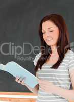 Portait of a young woman reading her notes while standing in fro