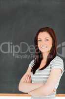 Portrait of a cute woman standing in front of a blackboard