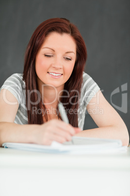 Portrait of a beautiful young student taking notes