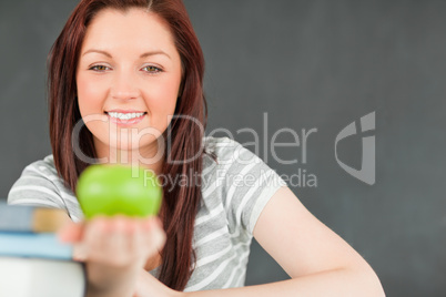 Cute young student showing an apple