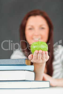 Portrait of a beautiful student showing an apple