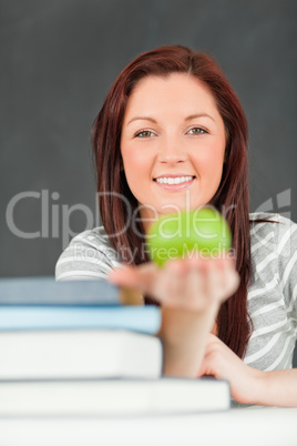 Portrait of a happy student showing an apple