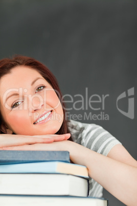 Portrait of a smiling young woman relying on her books