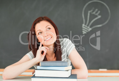 Smart young student in a classroom with a blackboard in the back