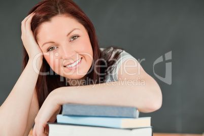 Close up of a smiling young student with her forearm on her book