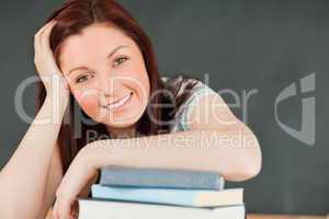 Close up of a smiling young student with her forearm on her book
