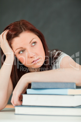 Beautiful bored student with her forearm on her books