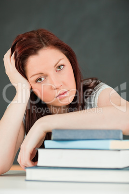 Close up of a tired student with her forearm om her books