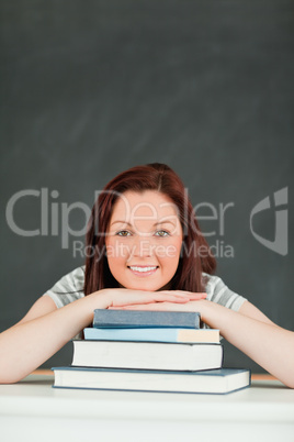 Smilling young student the chin on her books