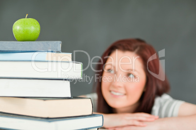 Young female student with a stack of books