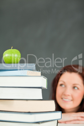 Young student with a stack of books and an apple