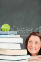 Young student with a stack of books and an apple