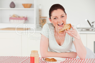 Good looking woman posing while eating a slice of bread