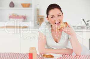 Good looking woman posing while eating a slice of bread