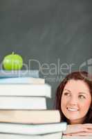 Portrait of a young student looking at the apple on the top of h
